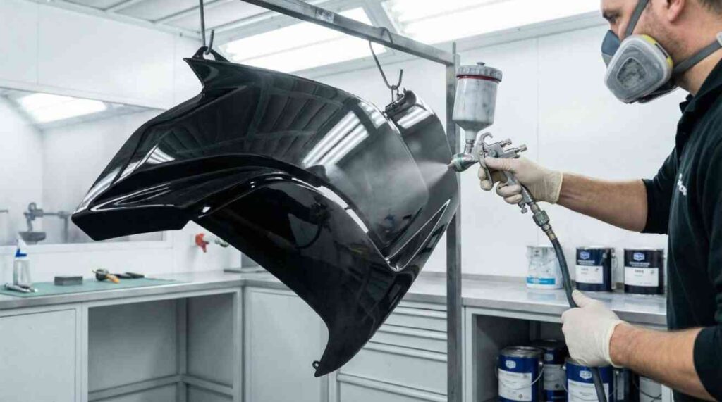 Realistic image of a person painting motorcycle plastics in a workshop, demonstrating the process of Painting Motorcycle Plastics with care and precision.